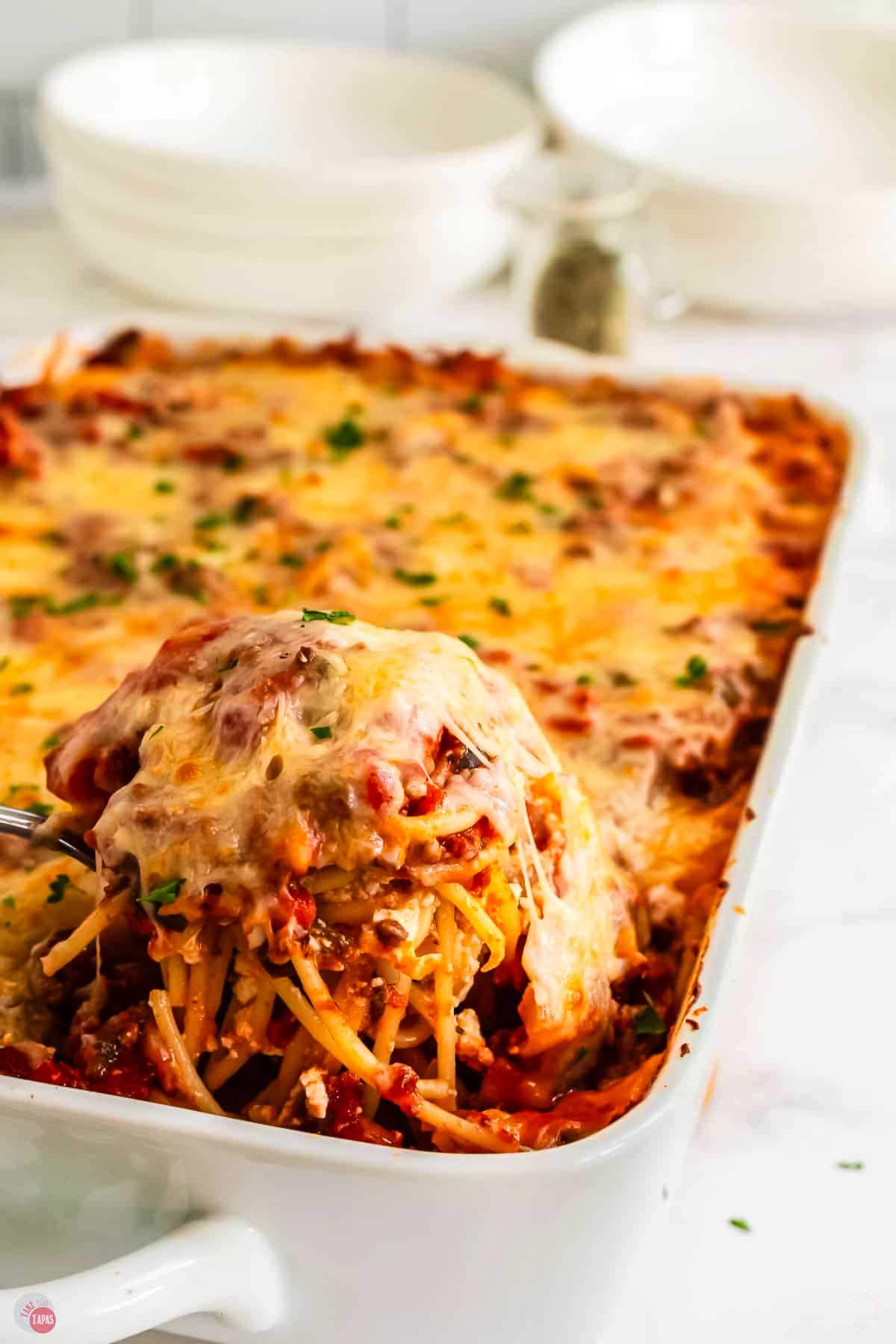spoon scooping spaghetti out of a dish