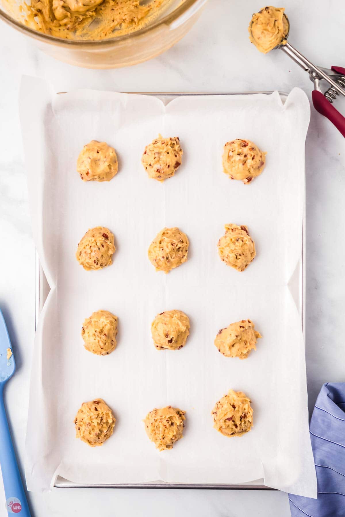unbaked cookie dough balls on a baking sheet