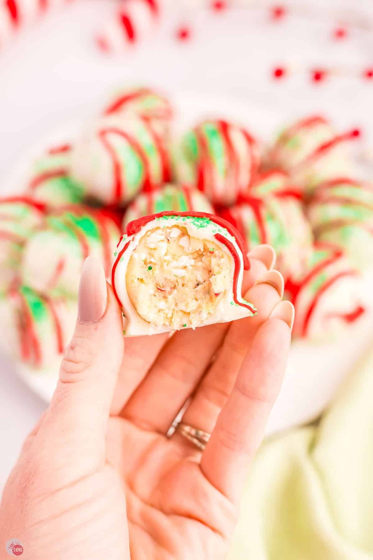 hand holding a cake ball with a bite missing