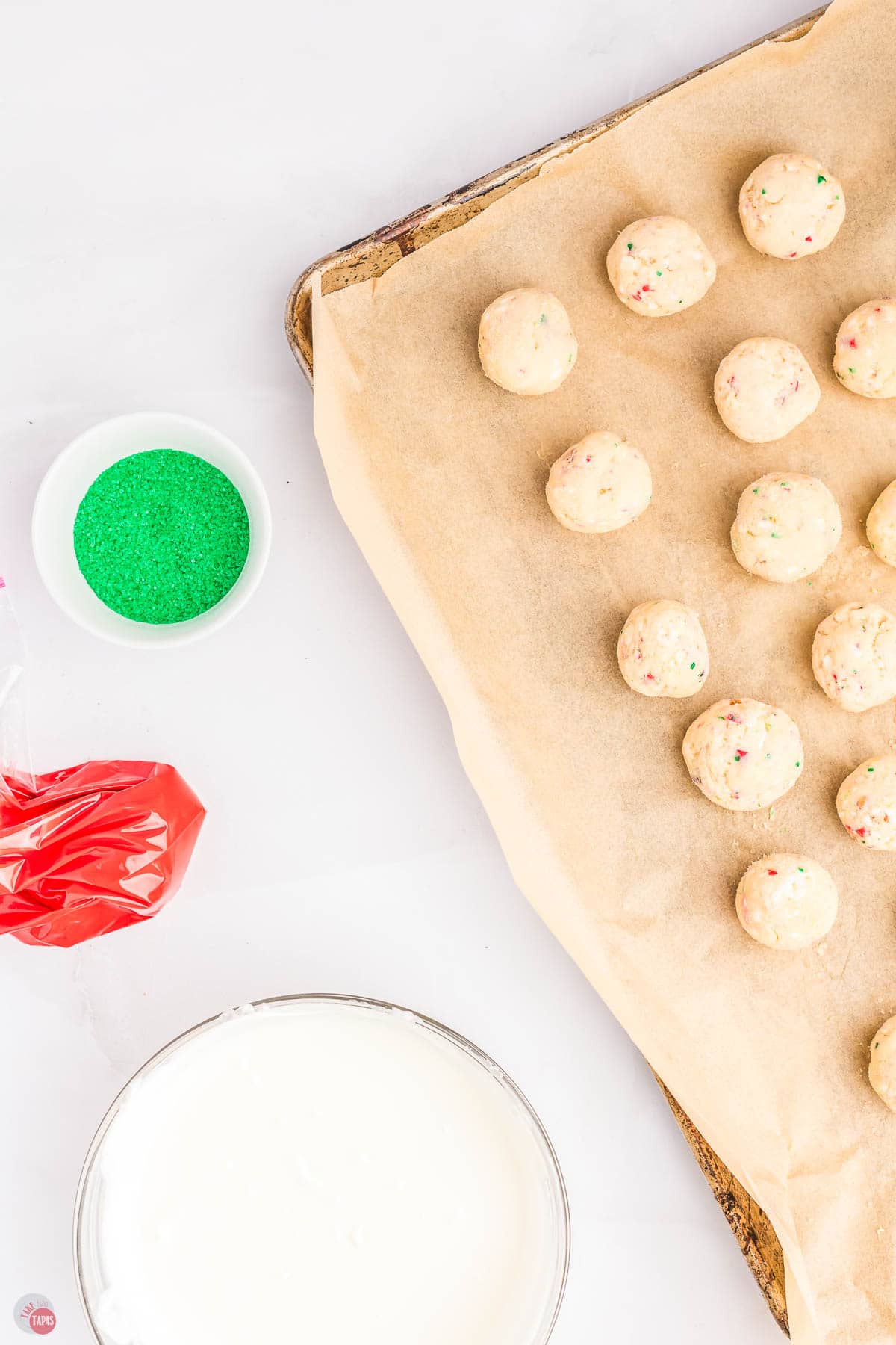 scoops of cake batter on a baking sheet with parchment paper