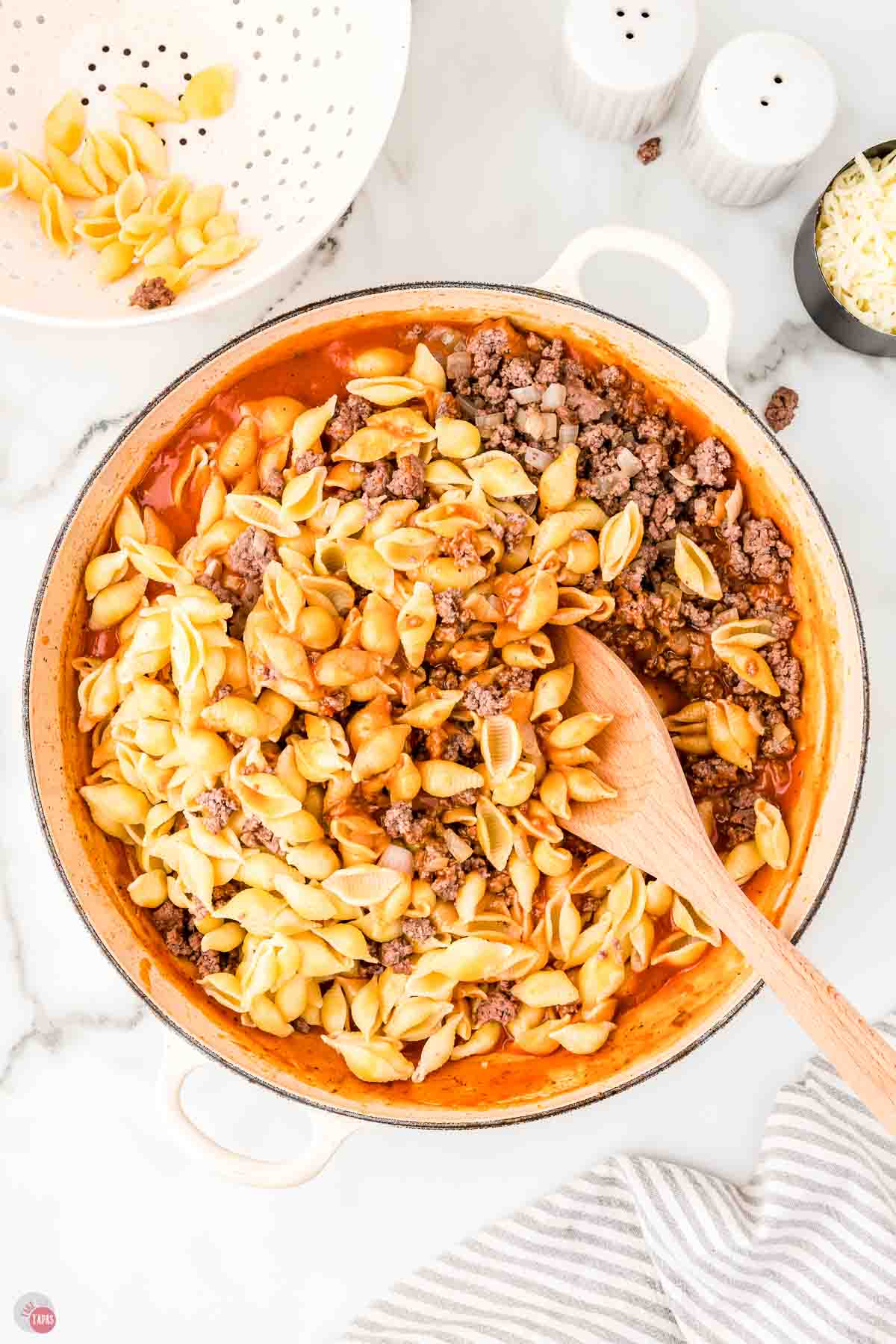 pot with pasta and cooked ground beef bring stirred into sauce