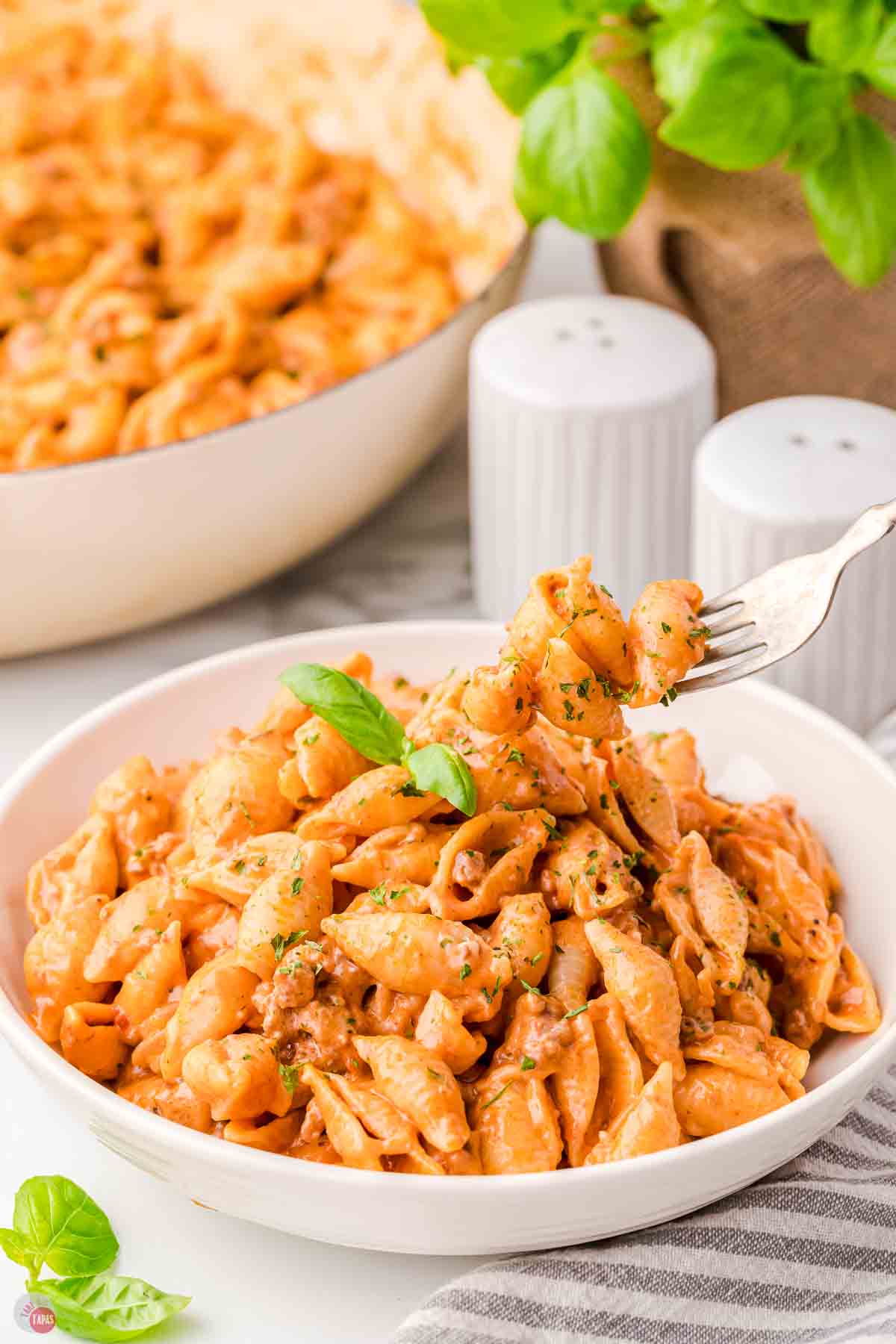 bowl of beef and shells with a fork taking a bite