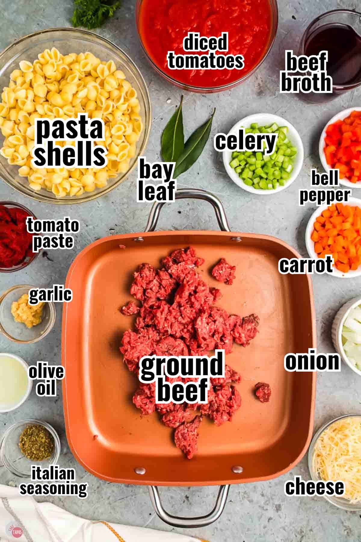 ingredients for a beefaroni recipe in individual bowls with text overlay labeling them