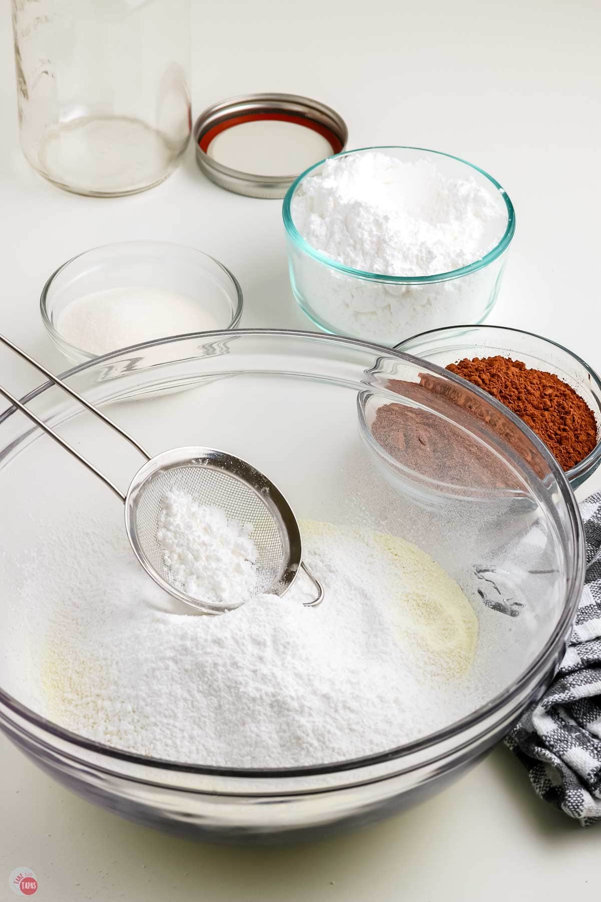 powdered sugar being sifted in a clear bowl