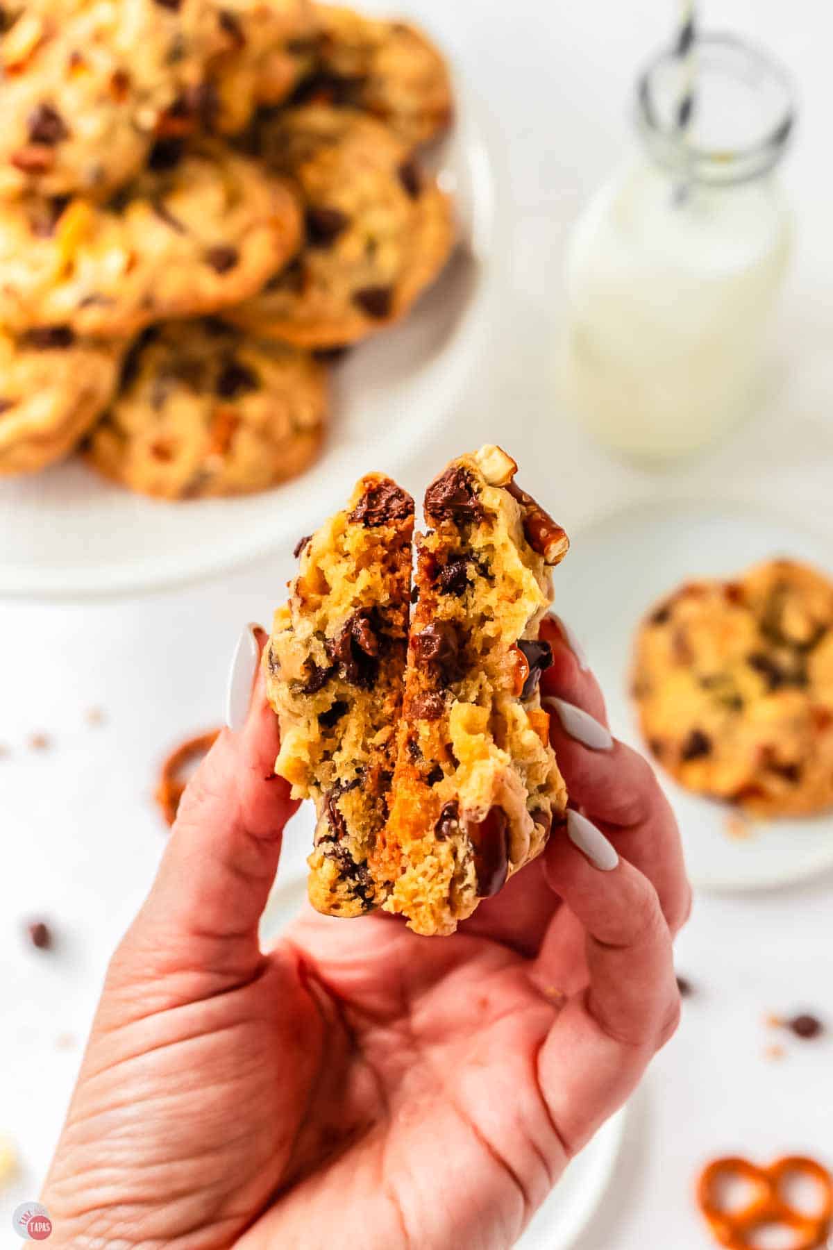 hand holding a cookie broken in half and showing the inside
