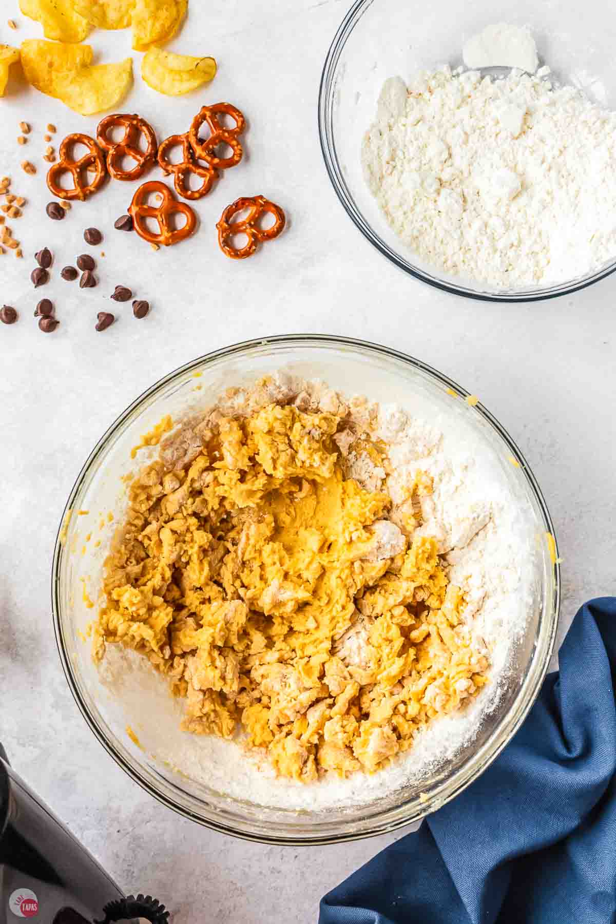 clear bowl of cookie dough next to a bowl of flour