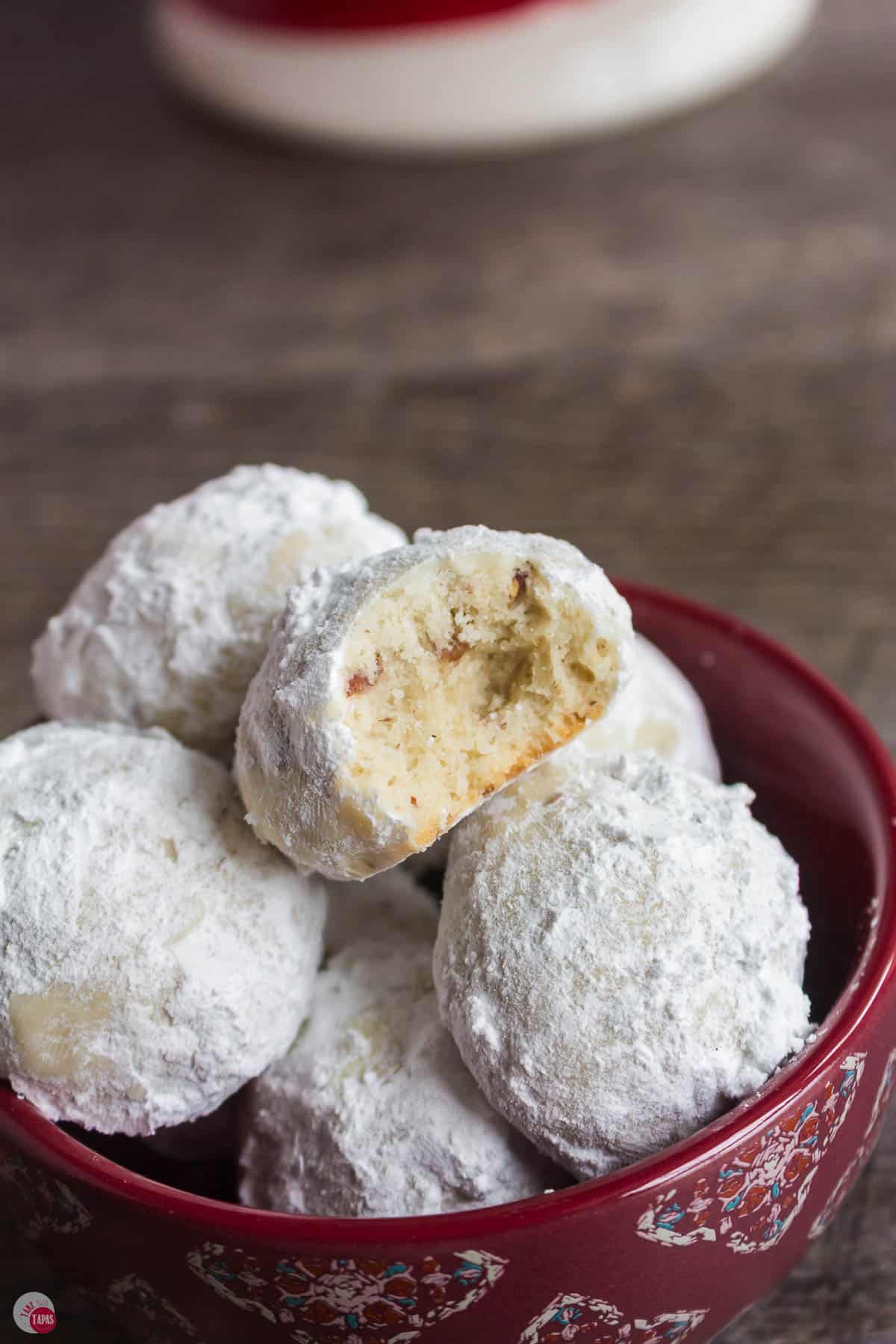 close up of cookie coated in powdered sugar with a bite missing