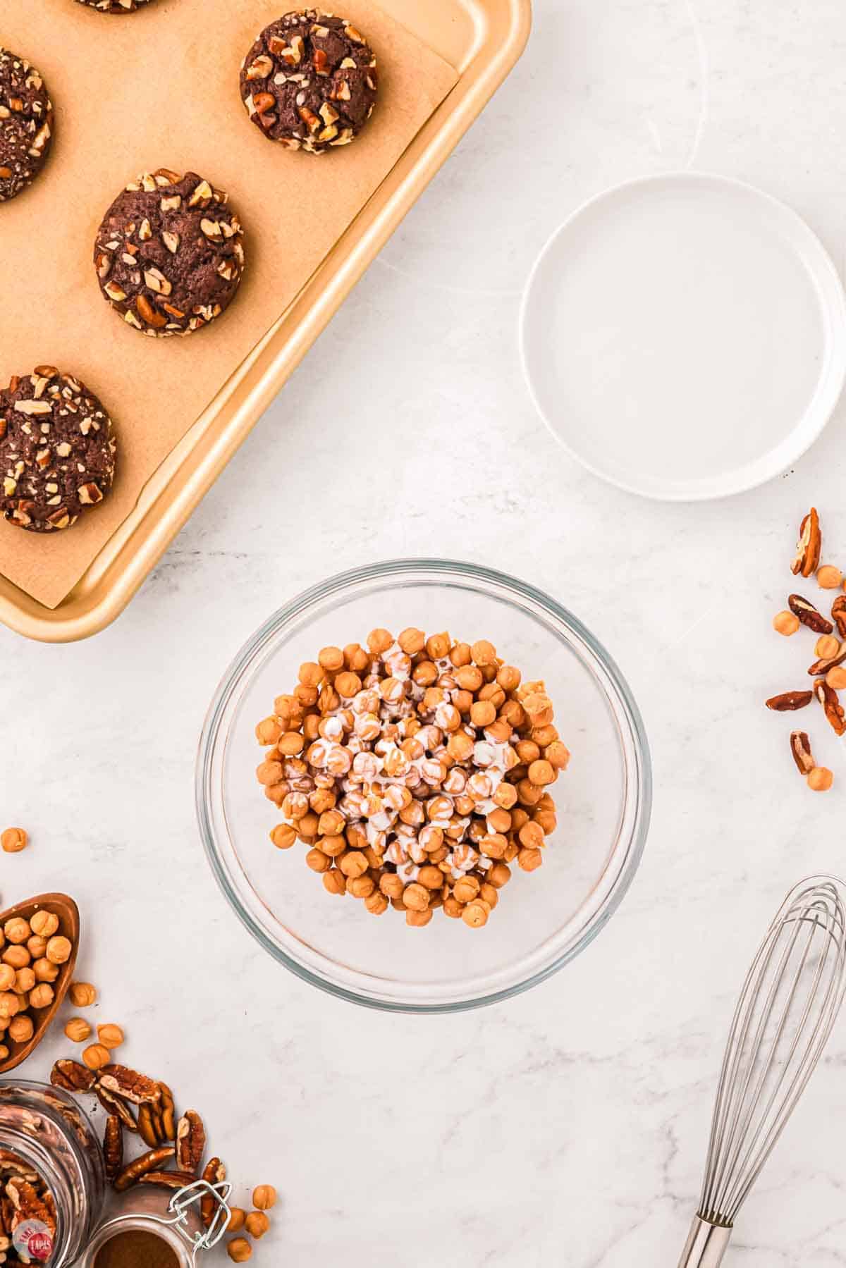 clear bowl of caramel bits topped with heavy cream