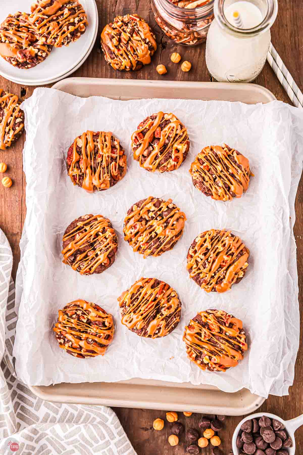 chocolate pecan cookies on parchment paper drizzled with caramel