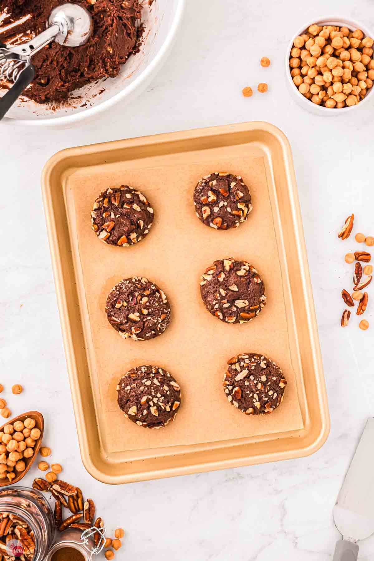 baked chocolate pecan cookies on a baking sheet