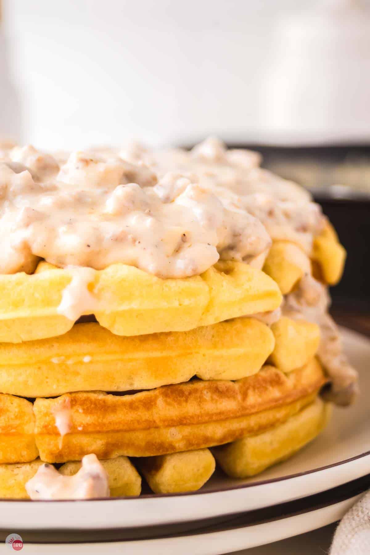 close up of stack of waffles with gravy on top