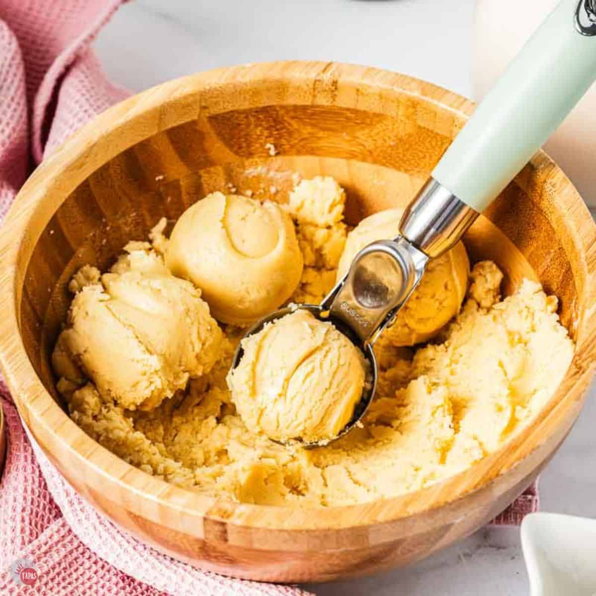 bowl of basic cookie dough with a scooper in it