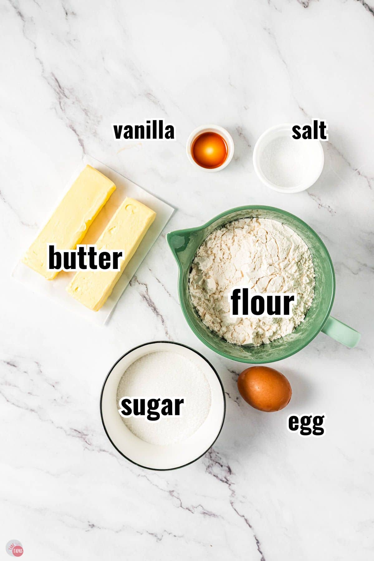ingredients for cookie dough in individual bowls with text overlay labeling them