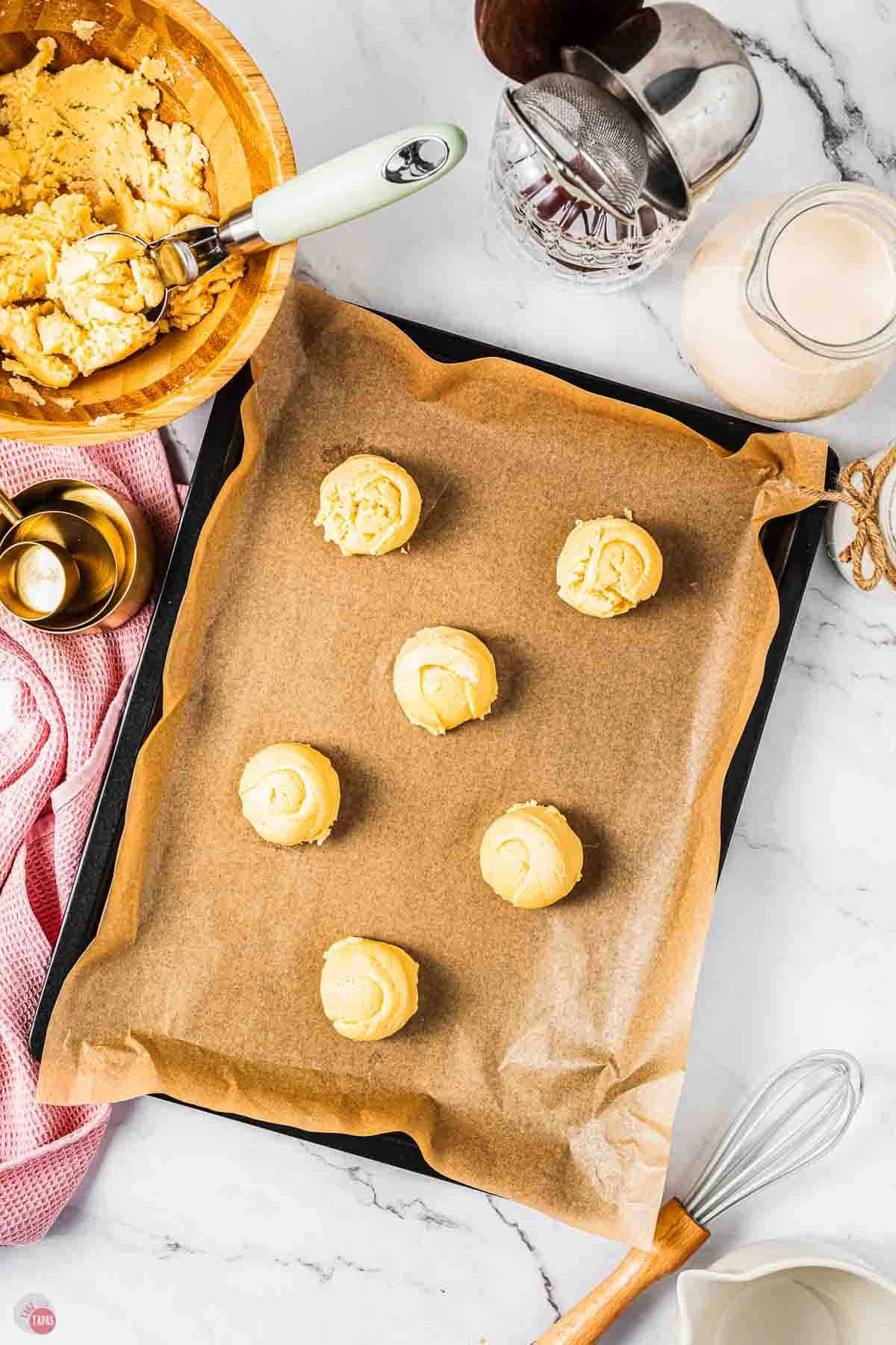 raw cookie dough on a baking sheet with parchment paper