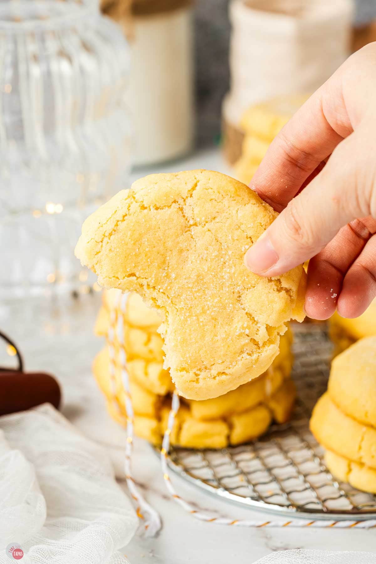 hand holding a sugar cookie with a bite missing