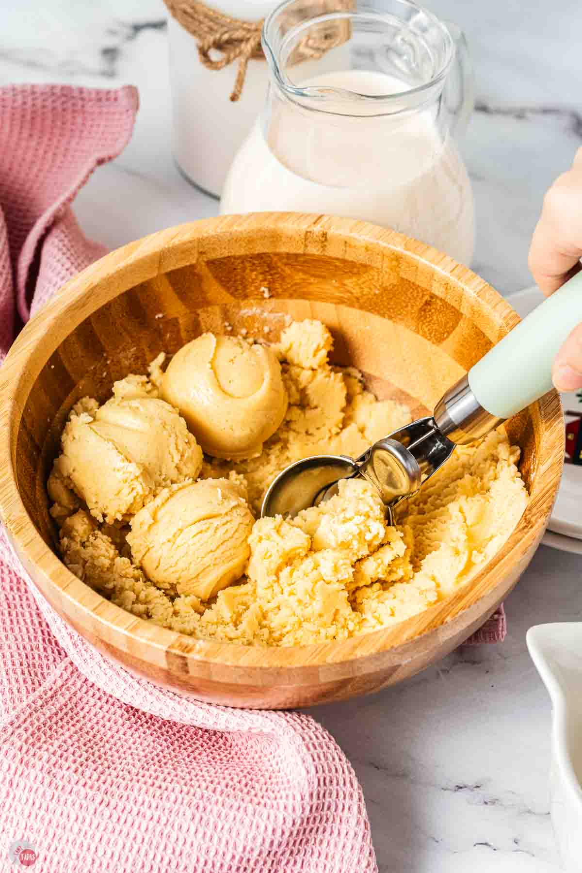 bowl of cookie dough with an ice cream scooper in it