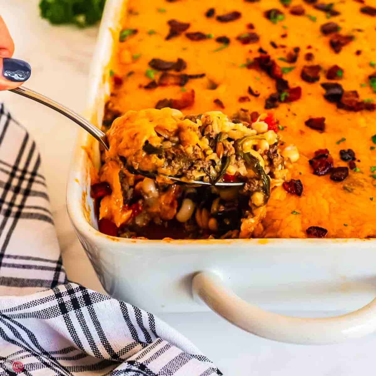 spoon with scoop of black eyed pea casserole and a blue and white napkin