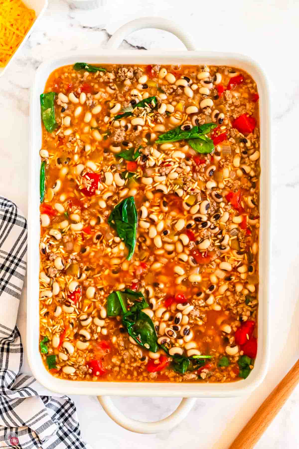 place black eyed peas and pork sausage in a white casserole dish