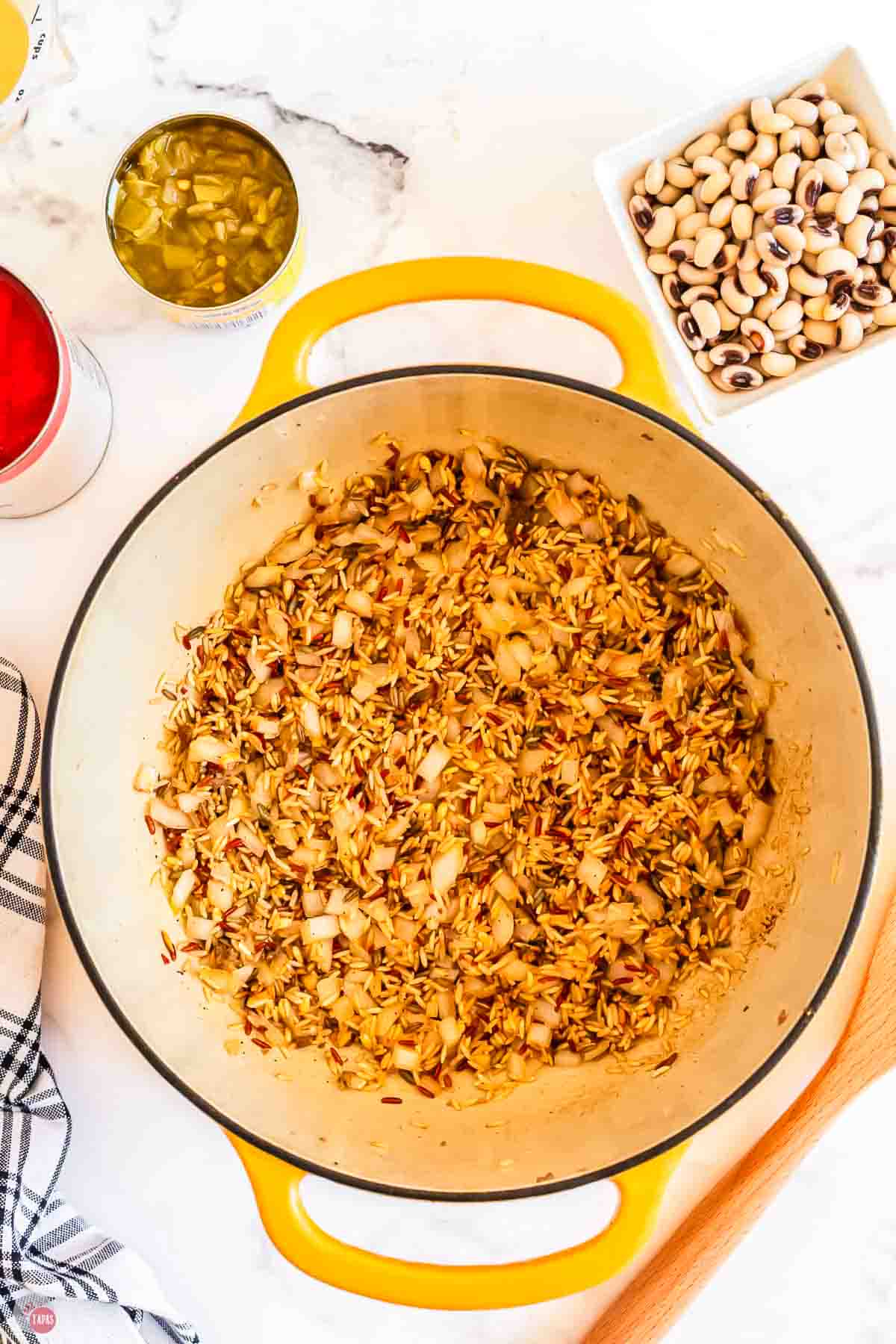 toasted rice and onion in a yellow pot
