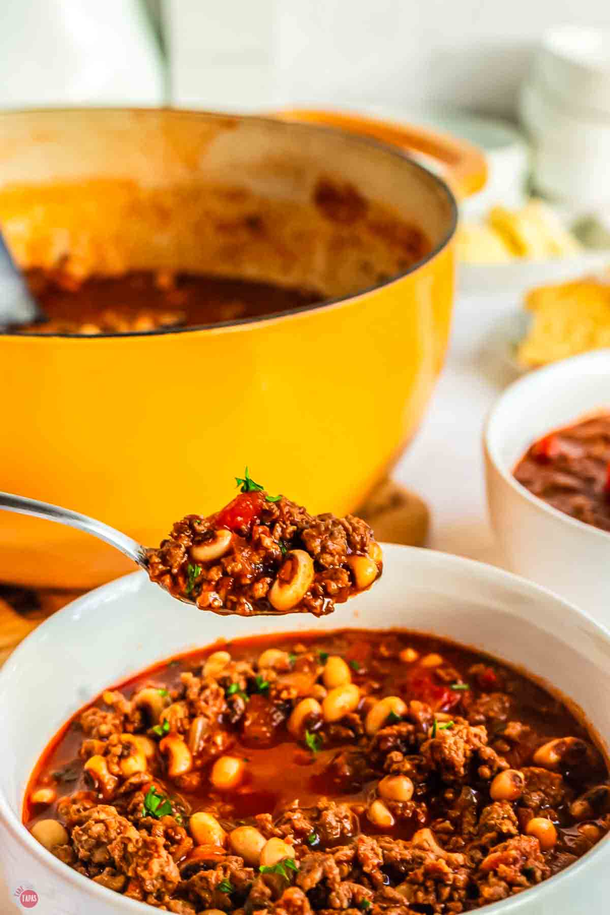 spoon of chili over a bowl of chili