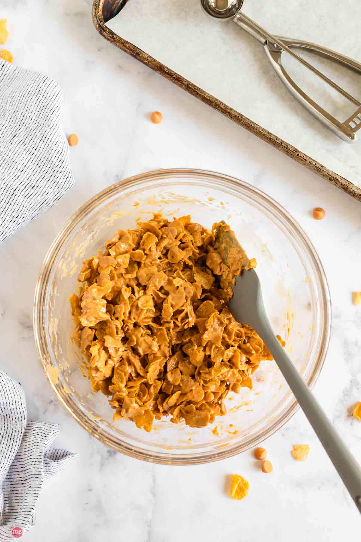cookie mixture in a clear bowl with a grey spatula