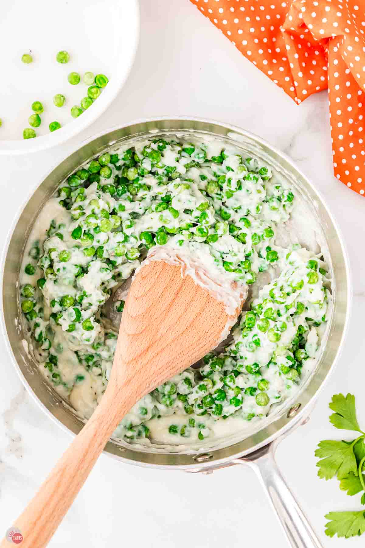 frozen peas and cream sauce in a silver skillet