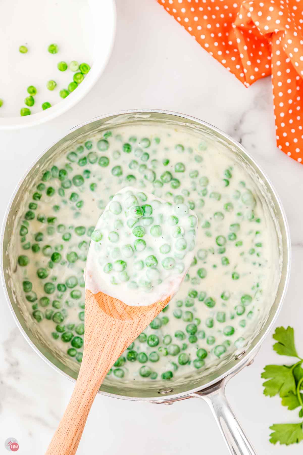 wood spoon with scoop of creamed peas