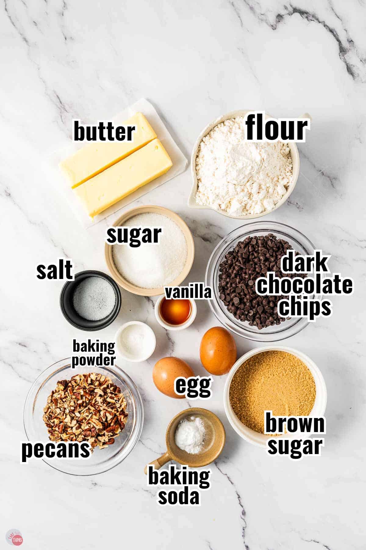 ingredients for cookie recipe in individual bowls with text overlay labeling them