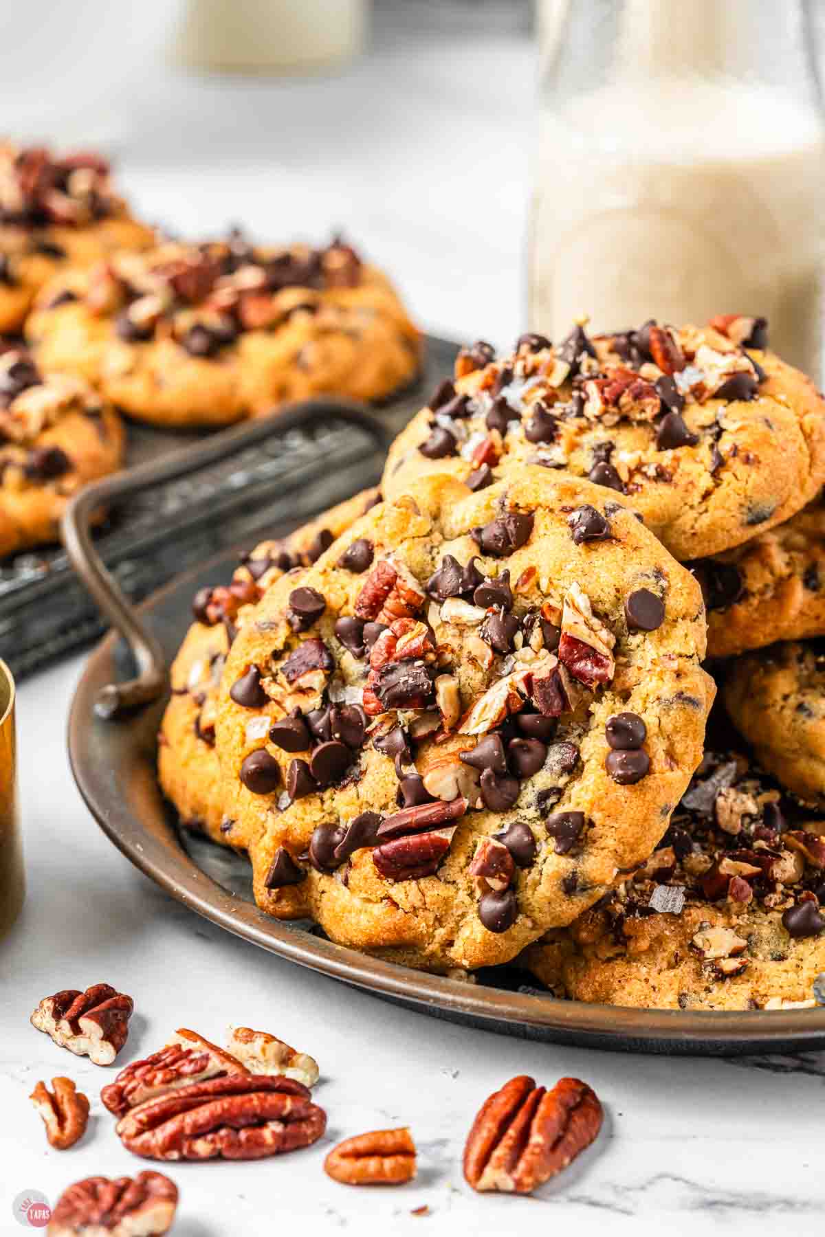 metal serving tray with cookies on it and a glass of milk