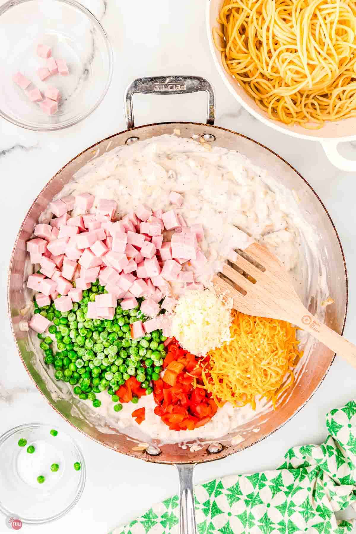 skillet with cream sauce, diced ham, and deiced vegetables
