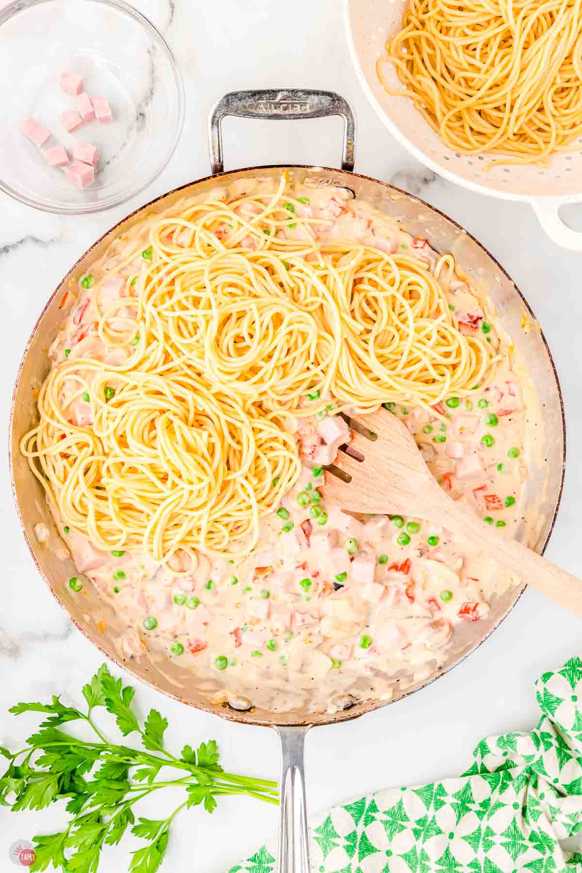 skillet with cooked ham and cooked spaghetti noodles