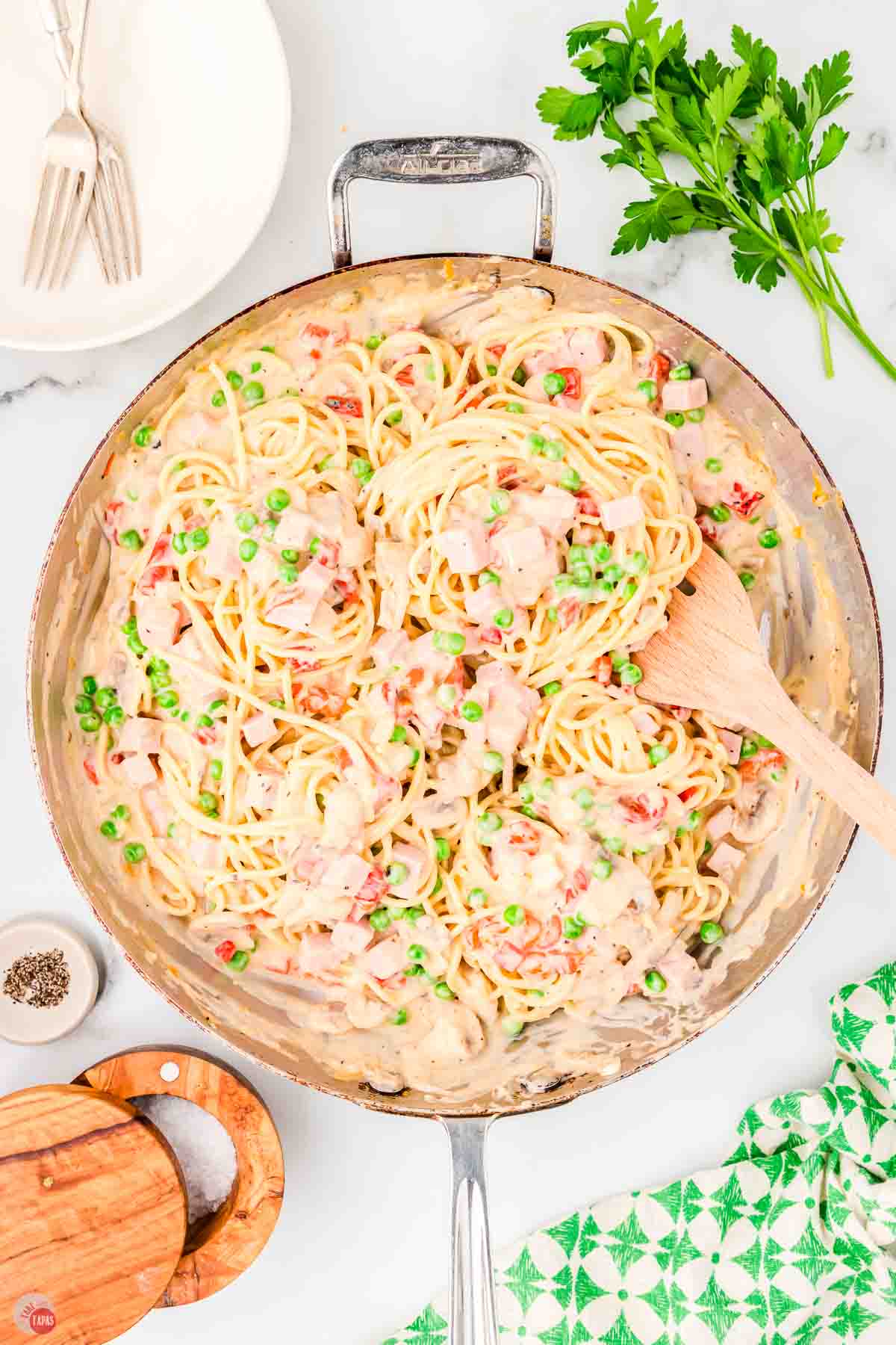 skillet with ham tetrazzini and a wood spoon