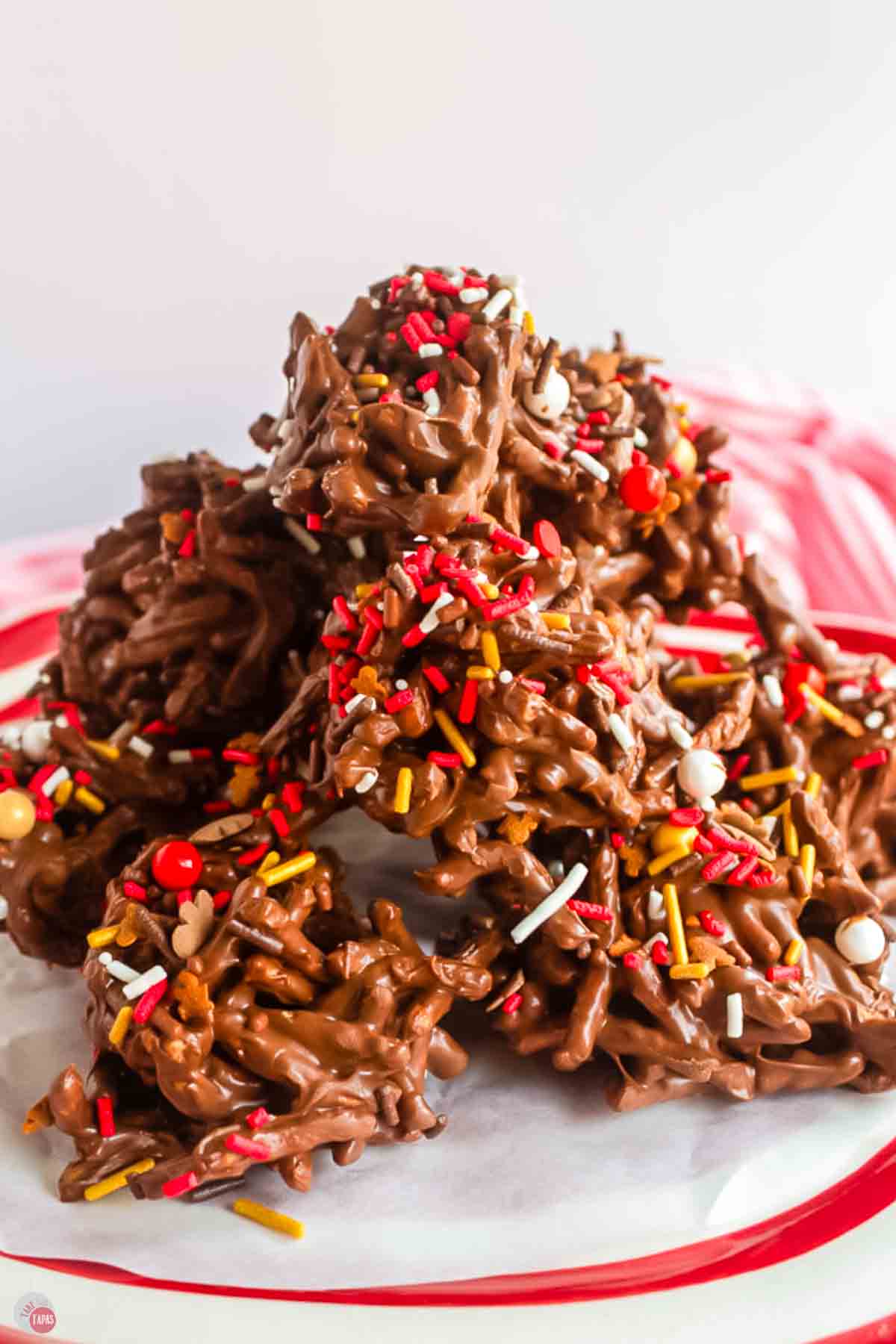 close up of haystack cookies on a white and red striped plate