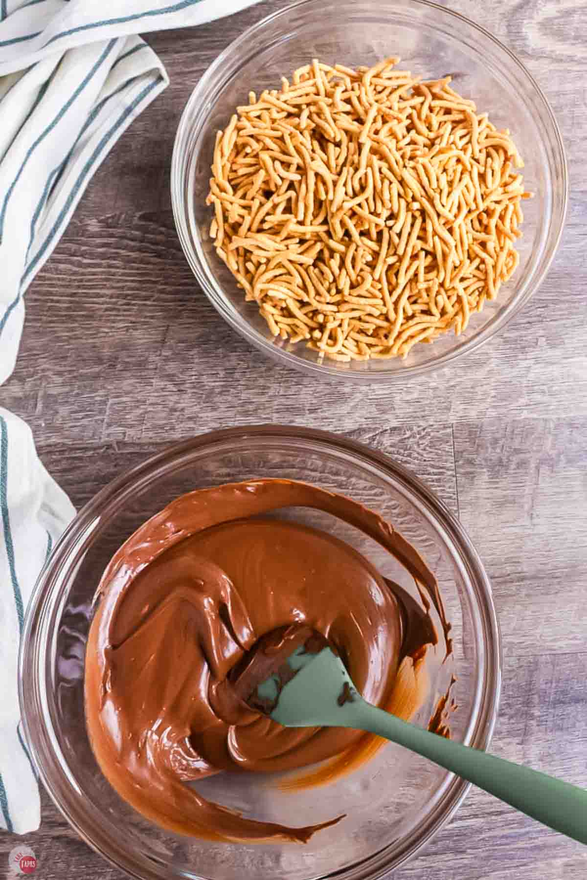 melted milk chocolate in a bowl next to a bowl of chow mein noodles