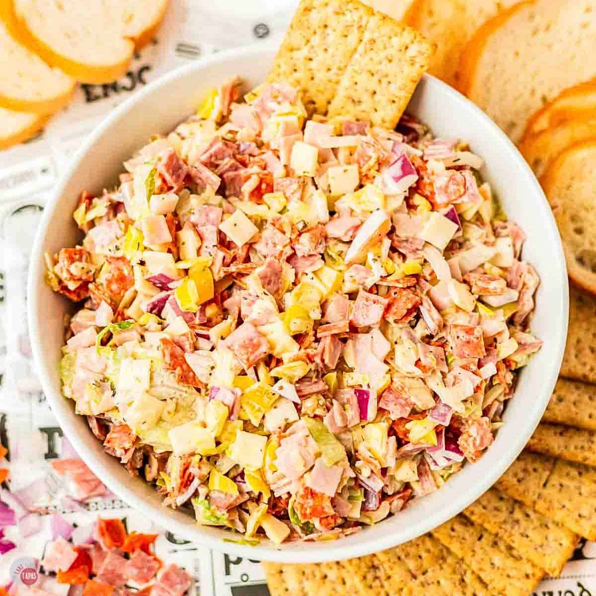 white bowl with Italian hoagie dip with crackers