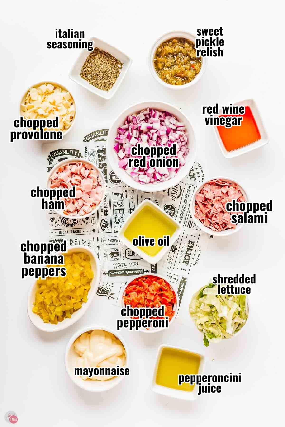 ingredients for a hoagie dip in individual bowls with text overlay labeling them