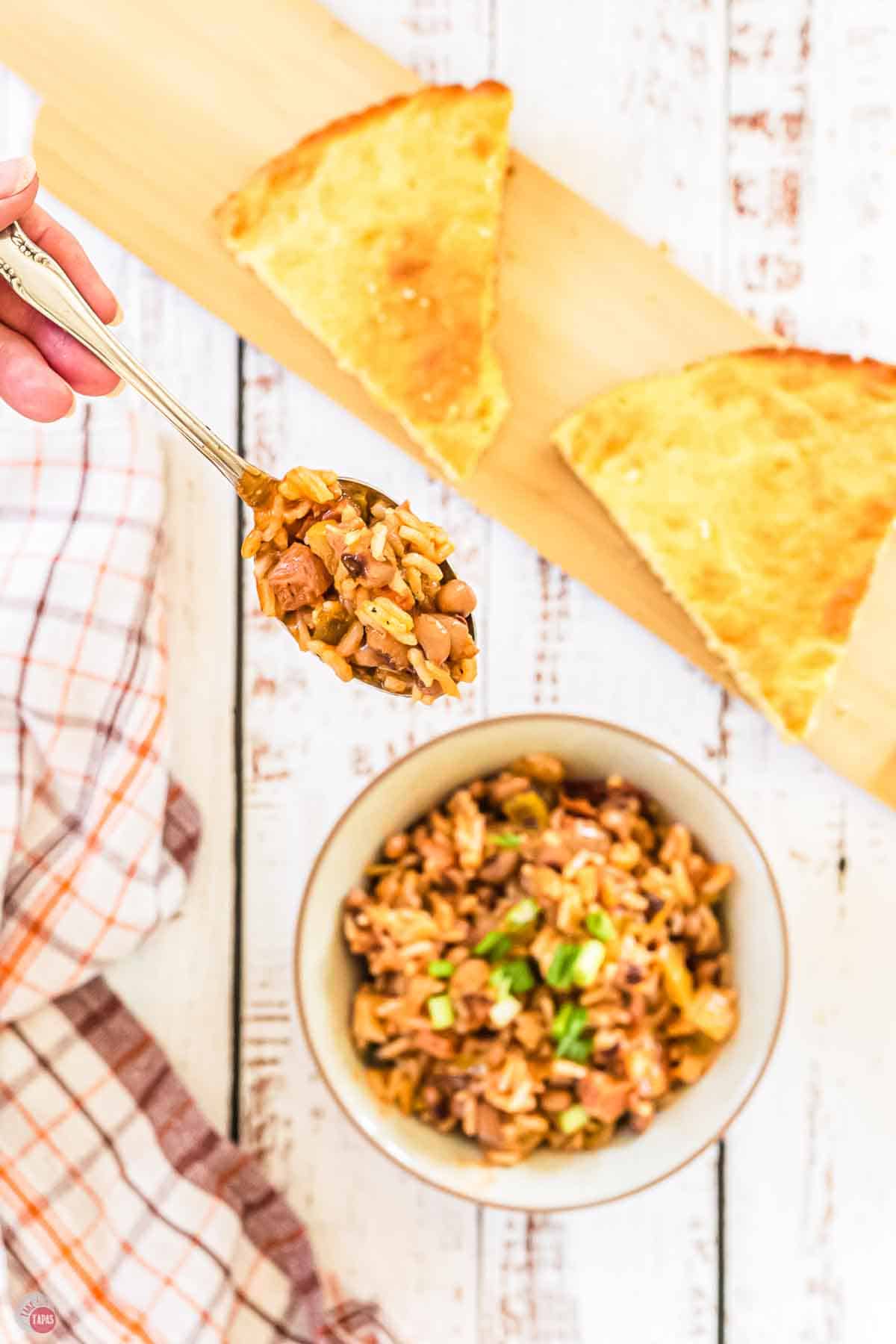 hand holding a spoon of peas and rice
