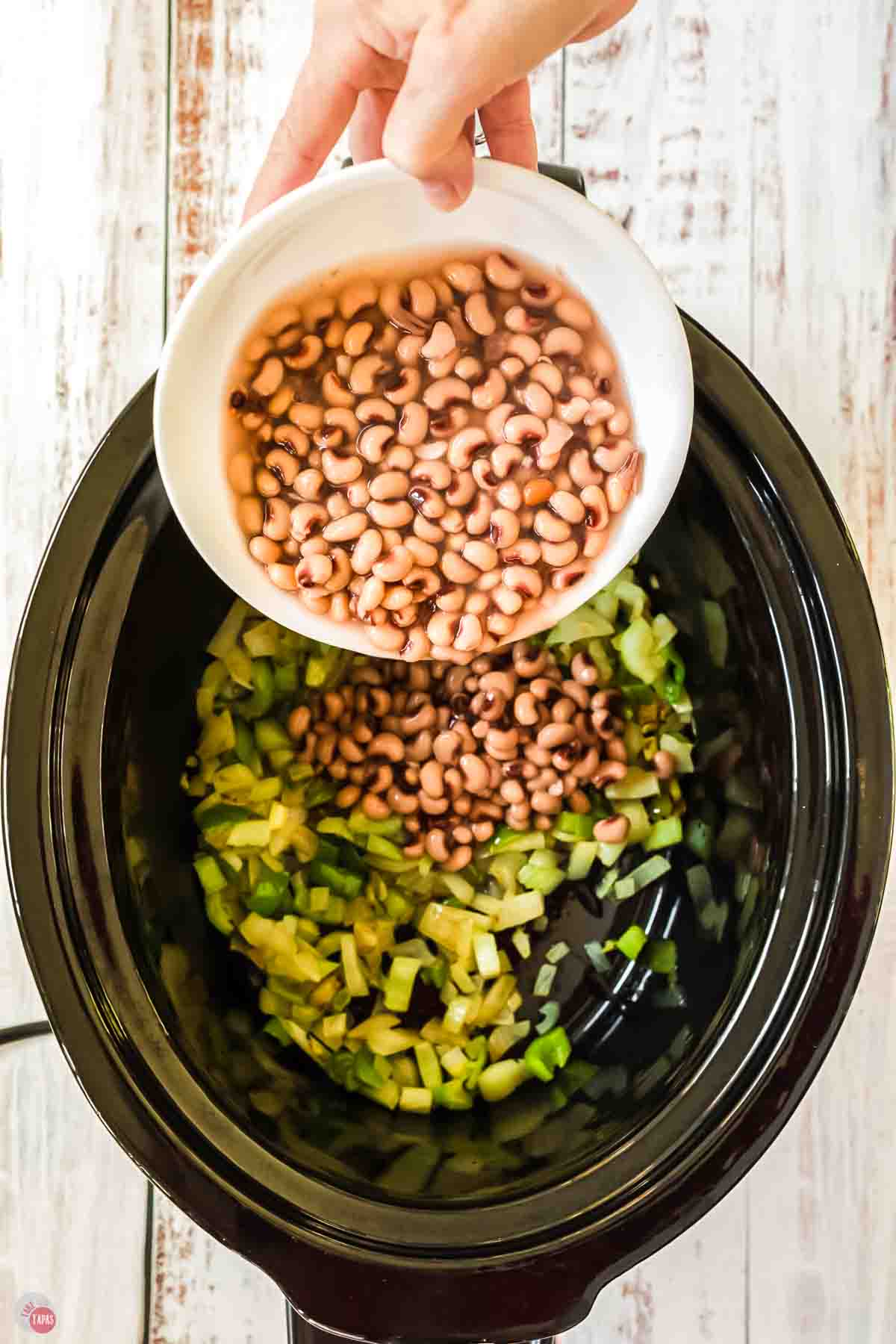 black eyed peas and celery in a slow cooker pot