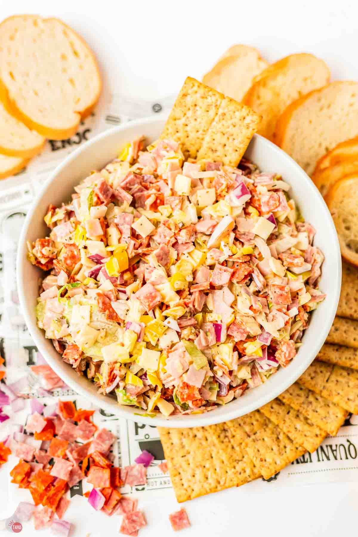 white bowl of chopped italian hoagie dip with sliced bread