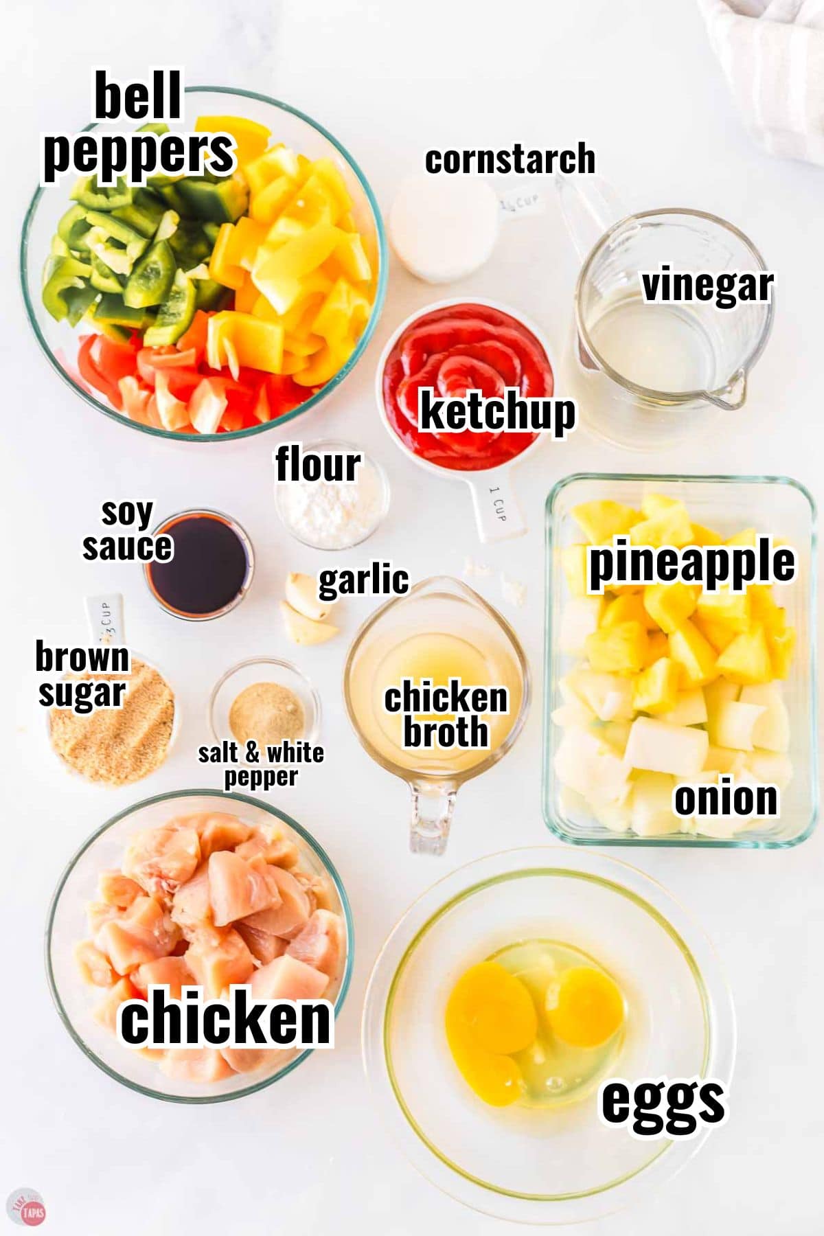 ingredients for sweet and sour chicken in individual bowls with text overlay labeling them