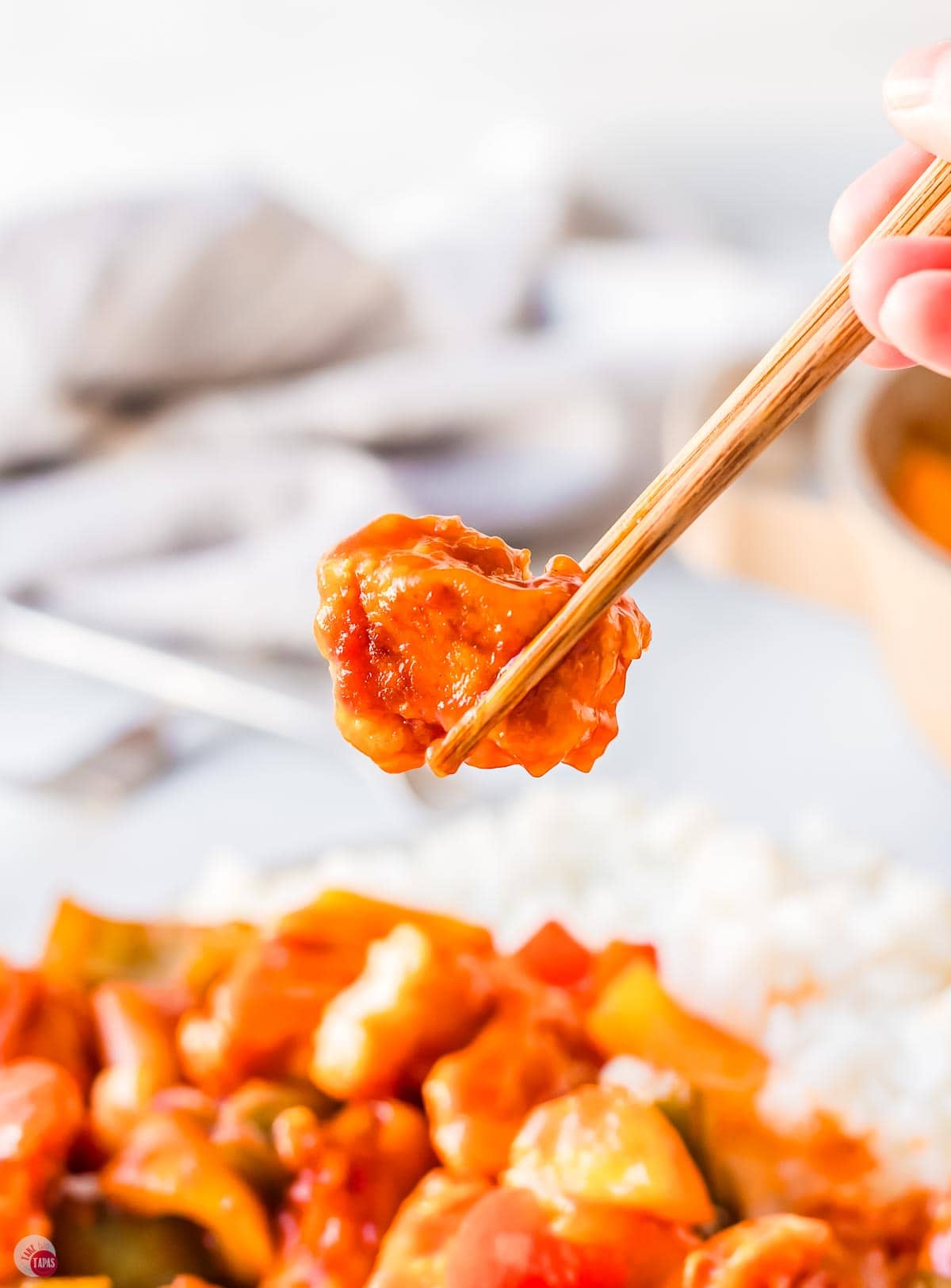chopstick holding a piece of chicken
