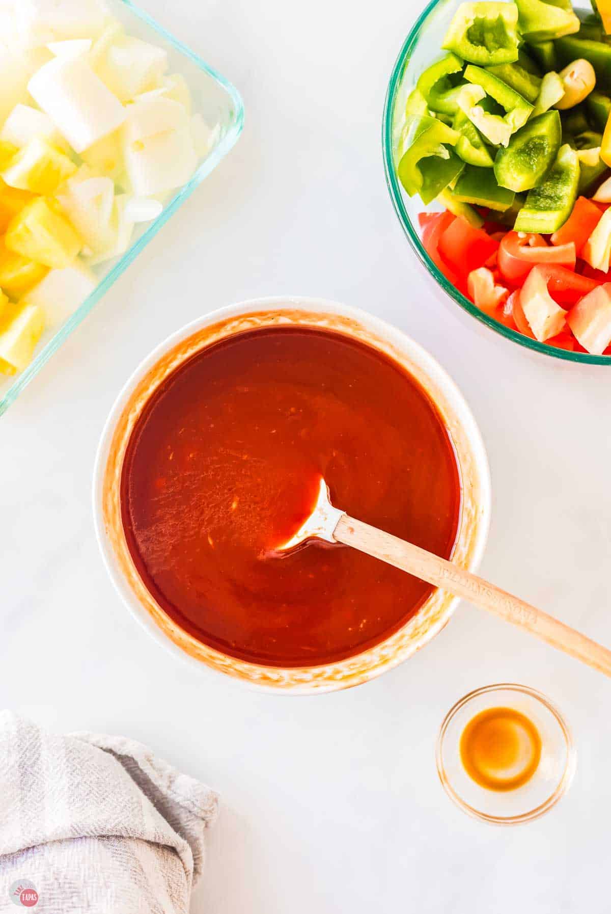 sweet and sour sauce in a small bowl with wood spoon