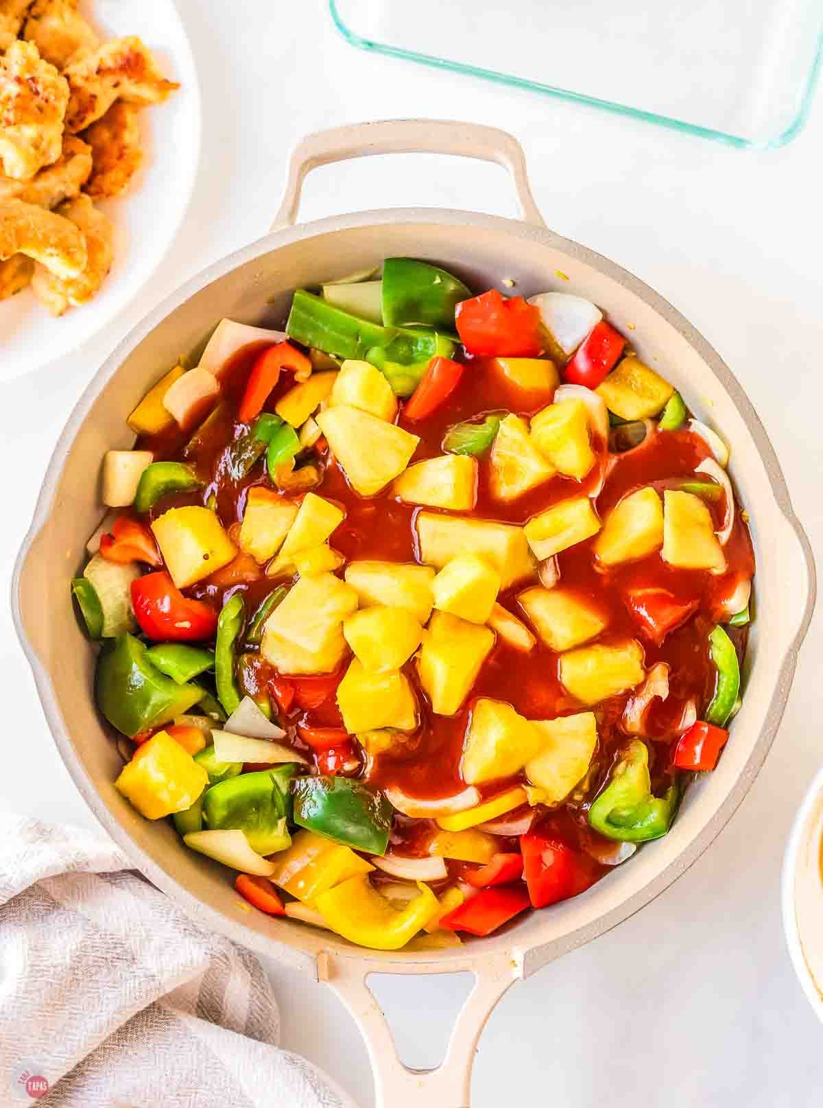 chopped bell peppers, onions, and pineapple in a skillet