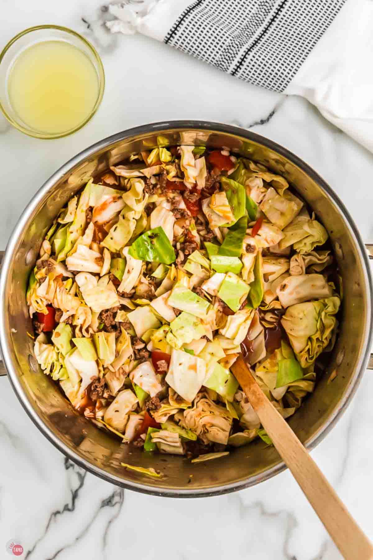 pot of cabbage roll soup cooking with a wood spoon