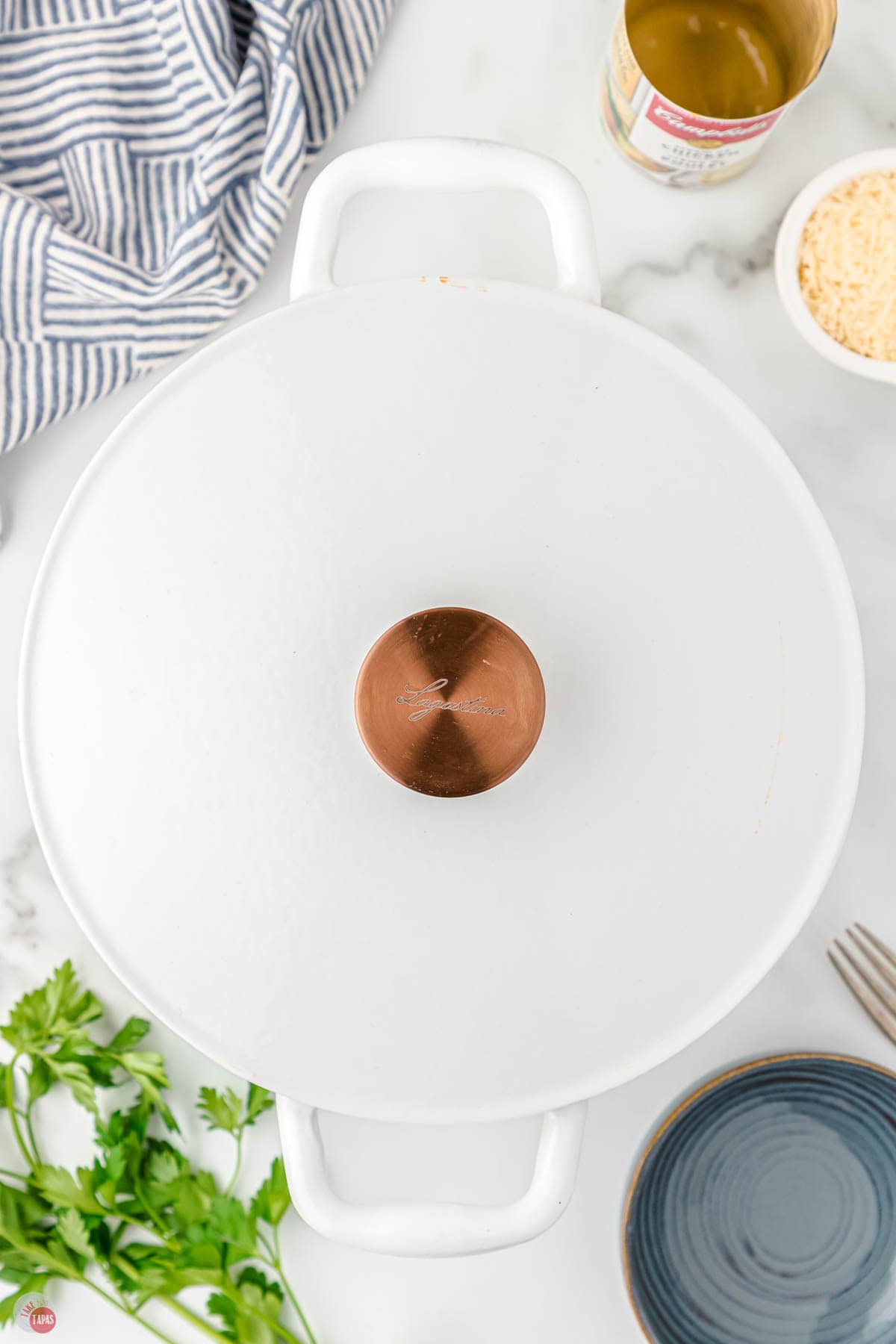 white pot with lid on it next to a bowl of cheese