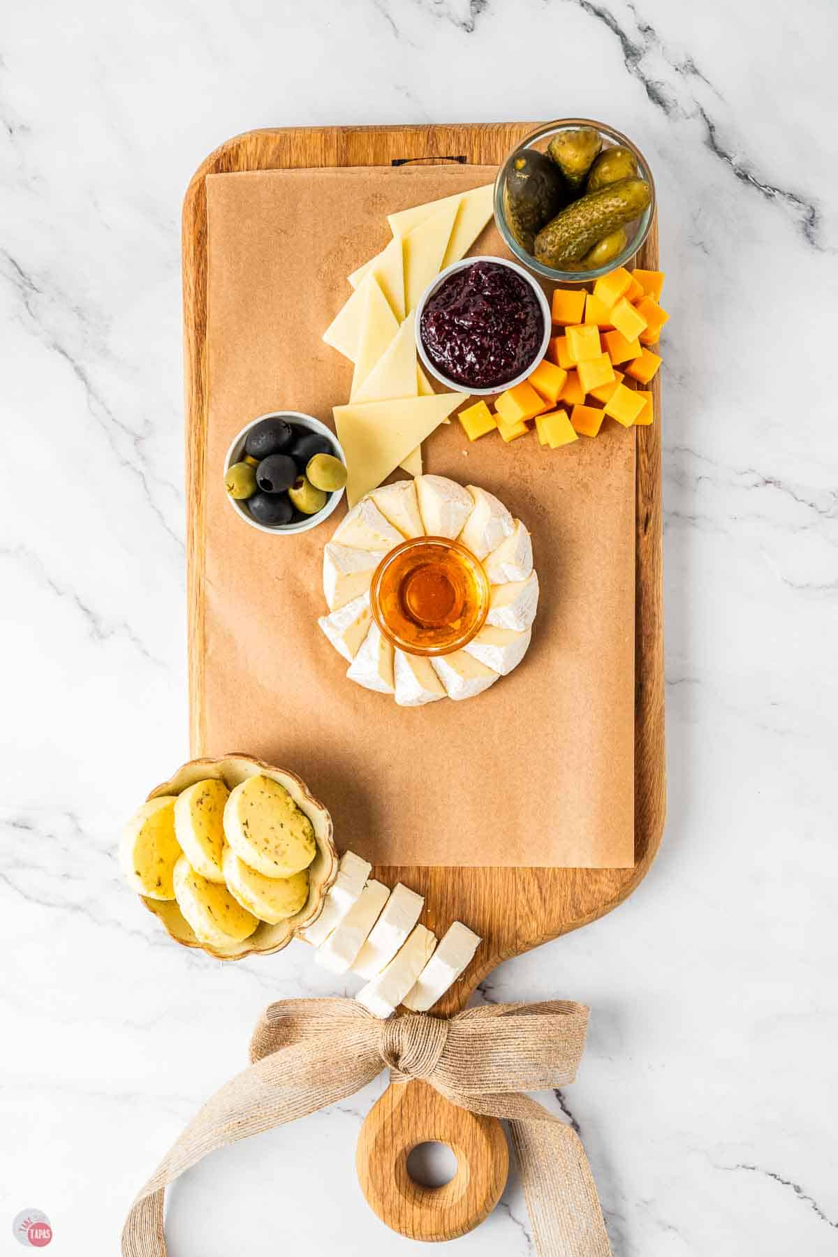 board with parchment paper and the kinds of cheese on it
