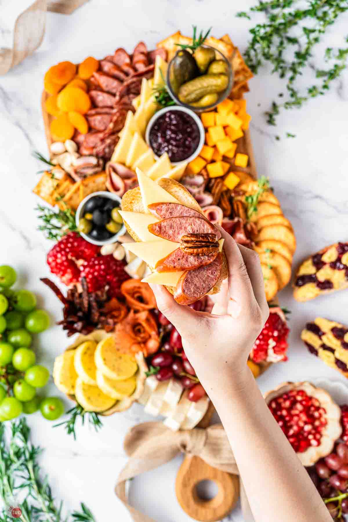 hand holding bread with meat and cheese