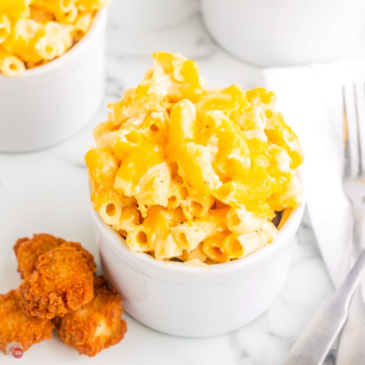 small bowl of Chick Fil A Macaroni and Cheese next to four chicken nuggets