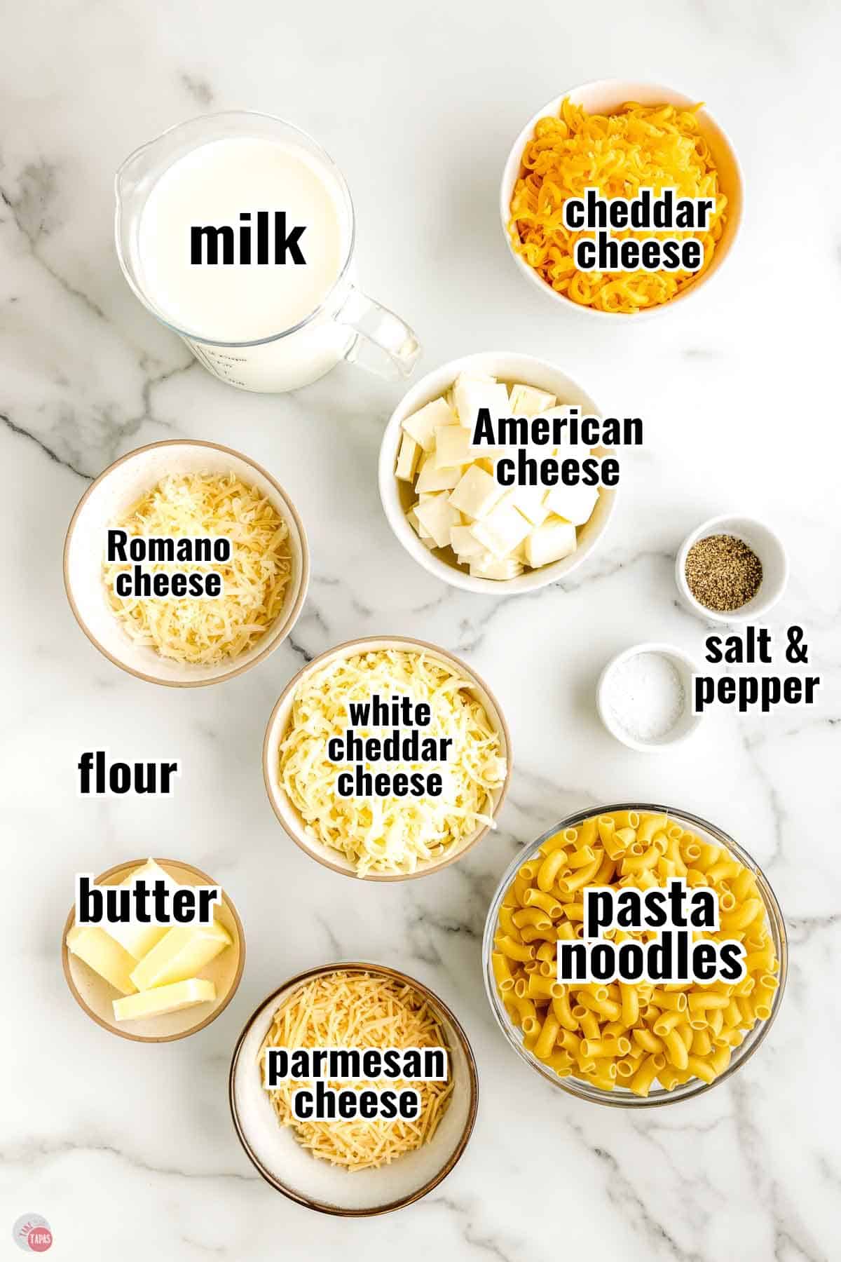 ingredients for a mac and cheese recipe in individual bowls with text overlay labeling them