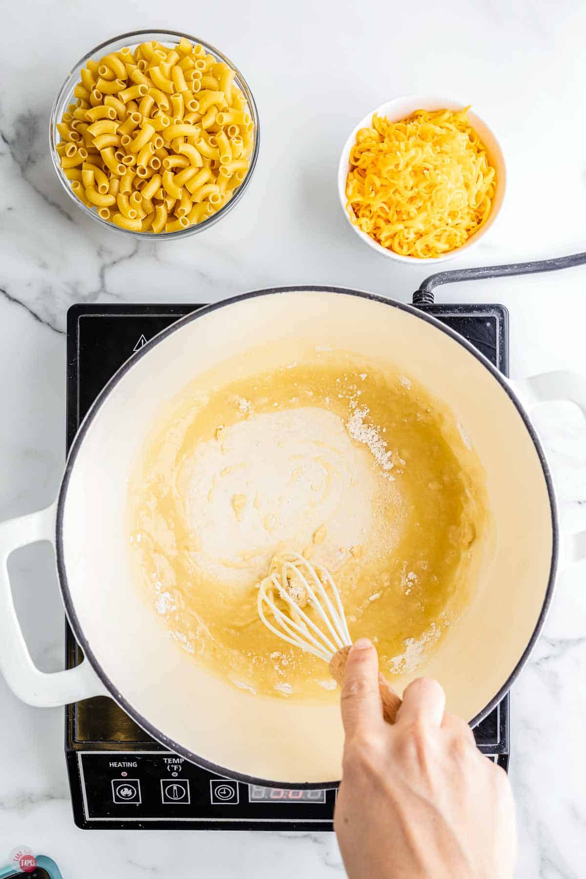 whisk making a roux in a white pot
